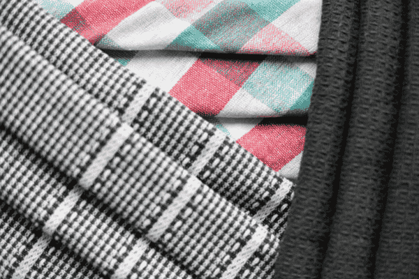 Layered fabrics with red, green, and black checkered patterns.