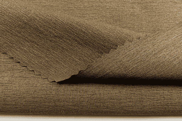 Close-up of folded brown knit fabric with a soft texture and zigzag-cut edge.