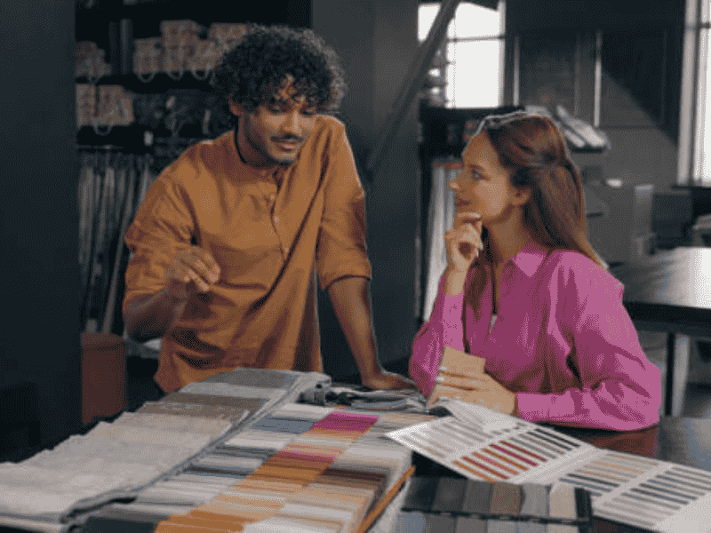 Two people discussing fabric samples in a factory setting